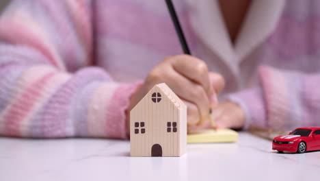 detail of female hand carrying out financial planning for investment in housing and transport