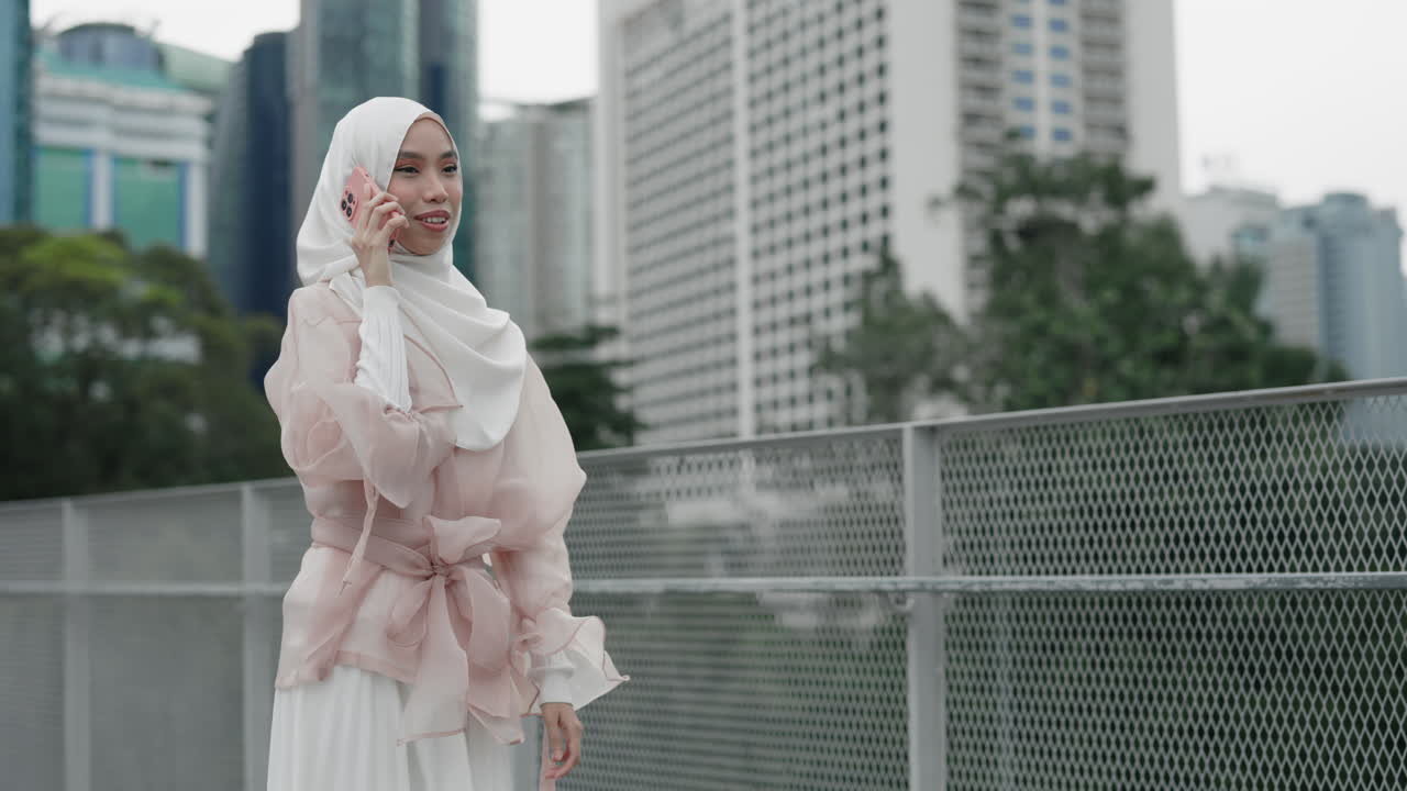 Wanita Muslim Berbicara di Telepon di Kota