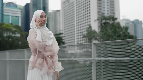 muslim woman talking on phone in city
