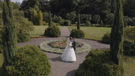 Newlyweds,-Caucasian-groom-with-bride-walking,-embracing,-hugs-in-park,-Wedding-couple