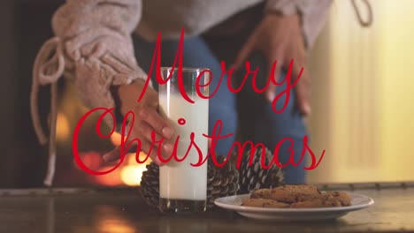 Animation-of-merry-christmas-text-over-hands-with-cookies-and-milk