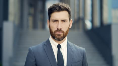 portrait young confident successful caucasian bearded businessman looking at camera serious business man