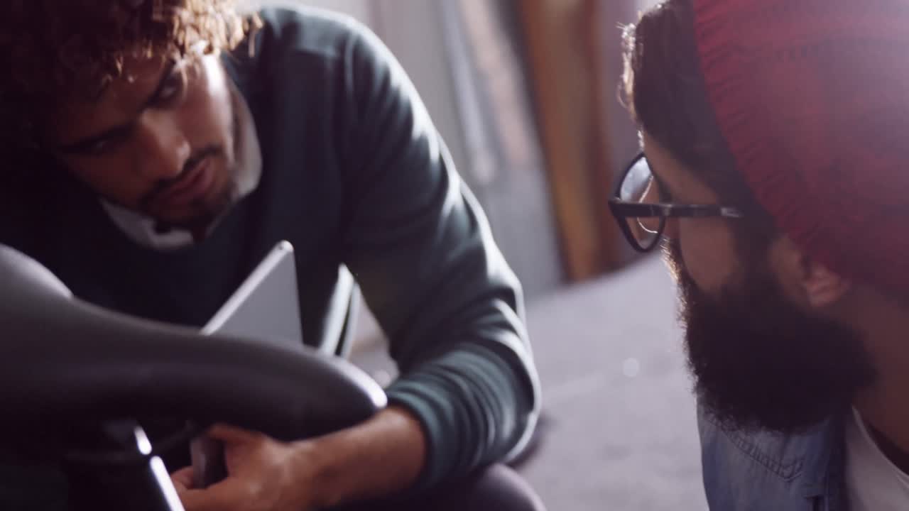 Mechanics repairing bicycle in workshop