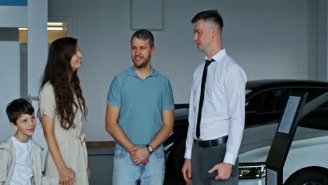 family visiting a car dealership