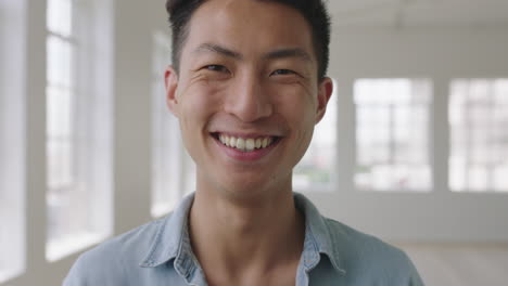 새로운 아파트에서 독립적 인 라이프 스타일 선택을 즐기는 미소 짓는 젊은 아시아 남자의 근접 초상화