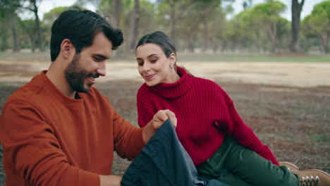 Family-couple-sitting-picnic-at-autumn-forest-closeup.-Pair-relaxing-on-blanket