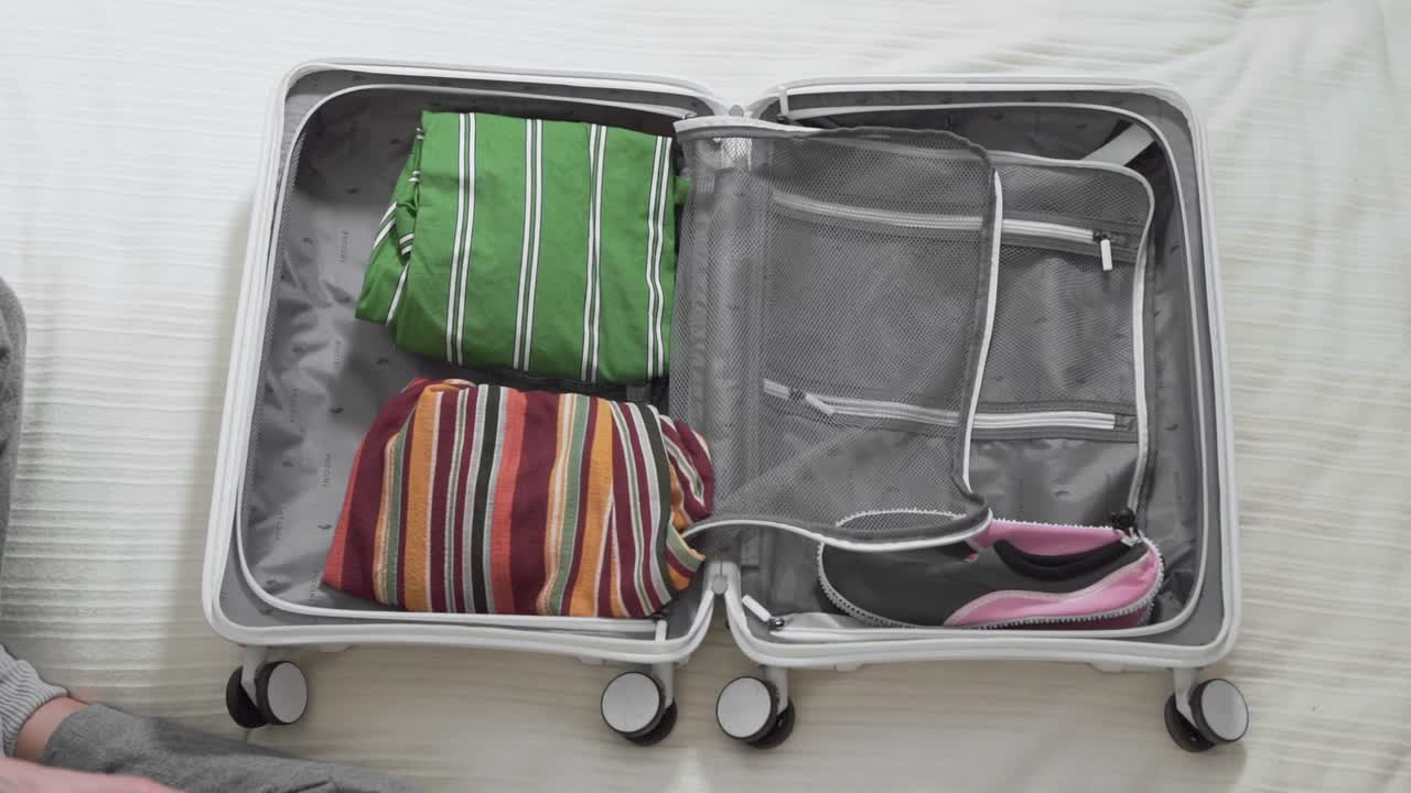 la ragazza raccoglie una valigia per le vacanze, vista dall'alto del primo piano