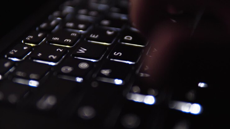 Backlit illuminated Notebook Keyboard Typing and Writing Close Up WASD