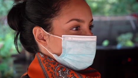 attractive young latina woman wearing a face mask while shopping - isolated