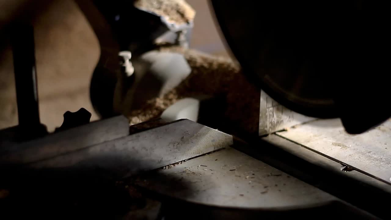 sierra de inglete aserrando madera con herramienta eléctrica en una fábrica metrajes