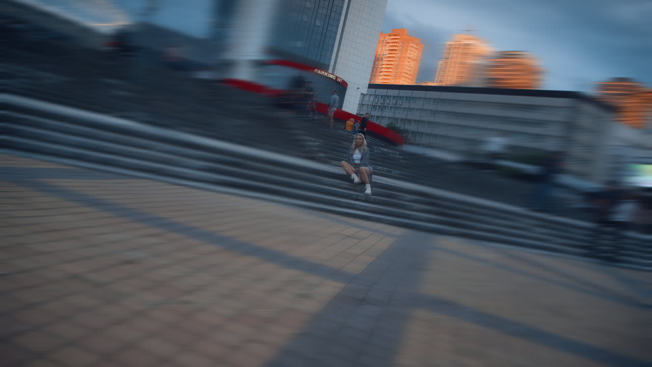 도시 배경에서 황혼에 저녁 시내 광장을  ⁇ 고 있는 사람들.