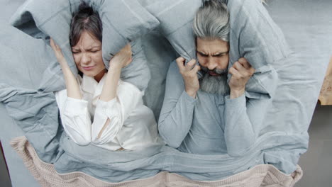 una pareja discutiendo en la cama.