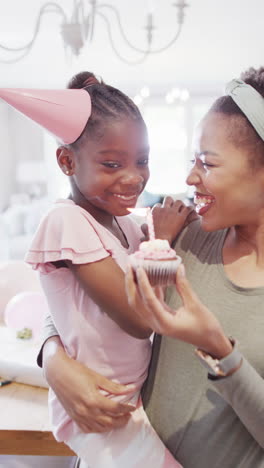 african american mother and child blowing out a birthday candle in slow motion video