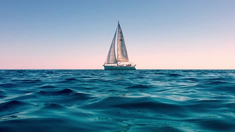 Acercar-Y-Ver-En-ángulo-Bajo-El-Nivel-Del-Mar-De-Un-Pequeño-Yate-Navegando-En-Mar-Abierto-En-Calma-Al-Atardecer