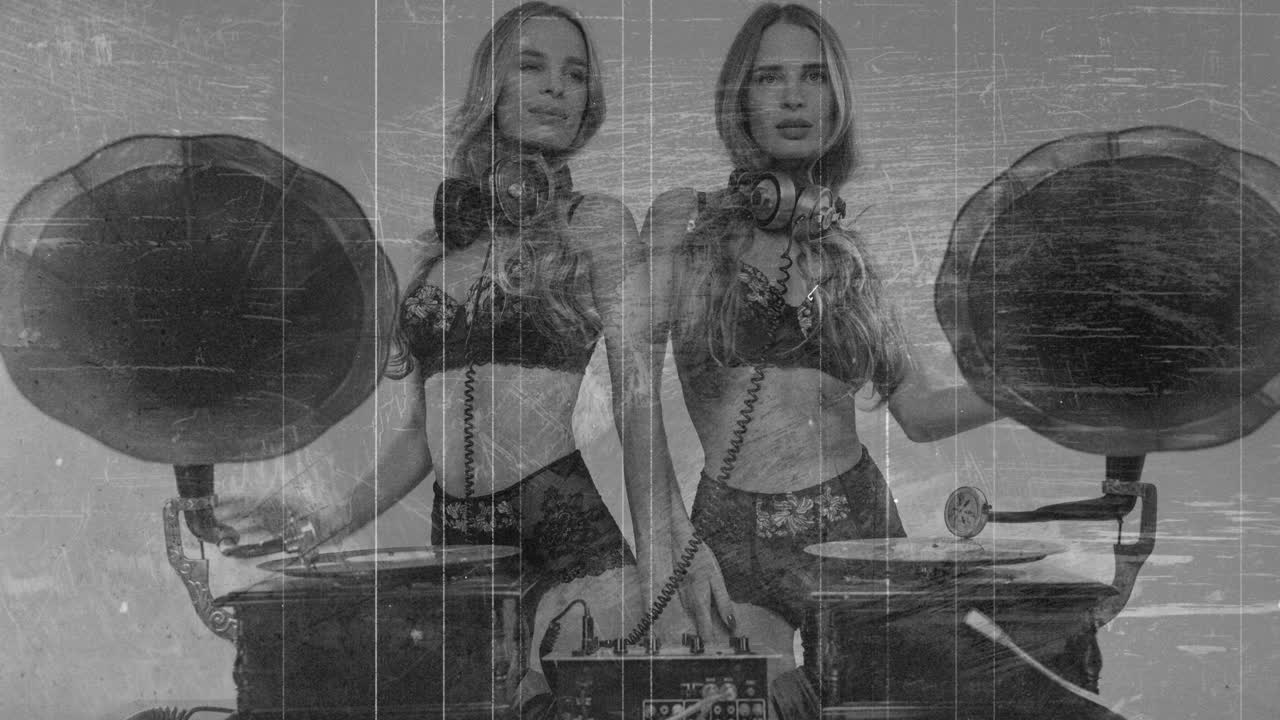 동일한 둥이 여성 dj가 오래된 영화 효과와 함께 빈티지 그라모폰 뒤에서 춤을 추고 있습니다.