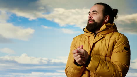 mountain hiker zipping his jacket after climbing to the top with vast landscape