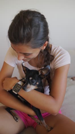 young woman lovingly holds her small dog