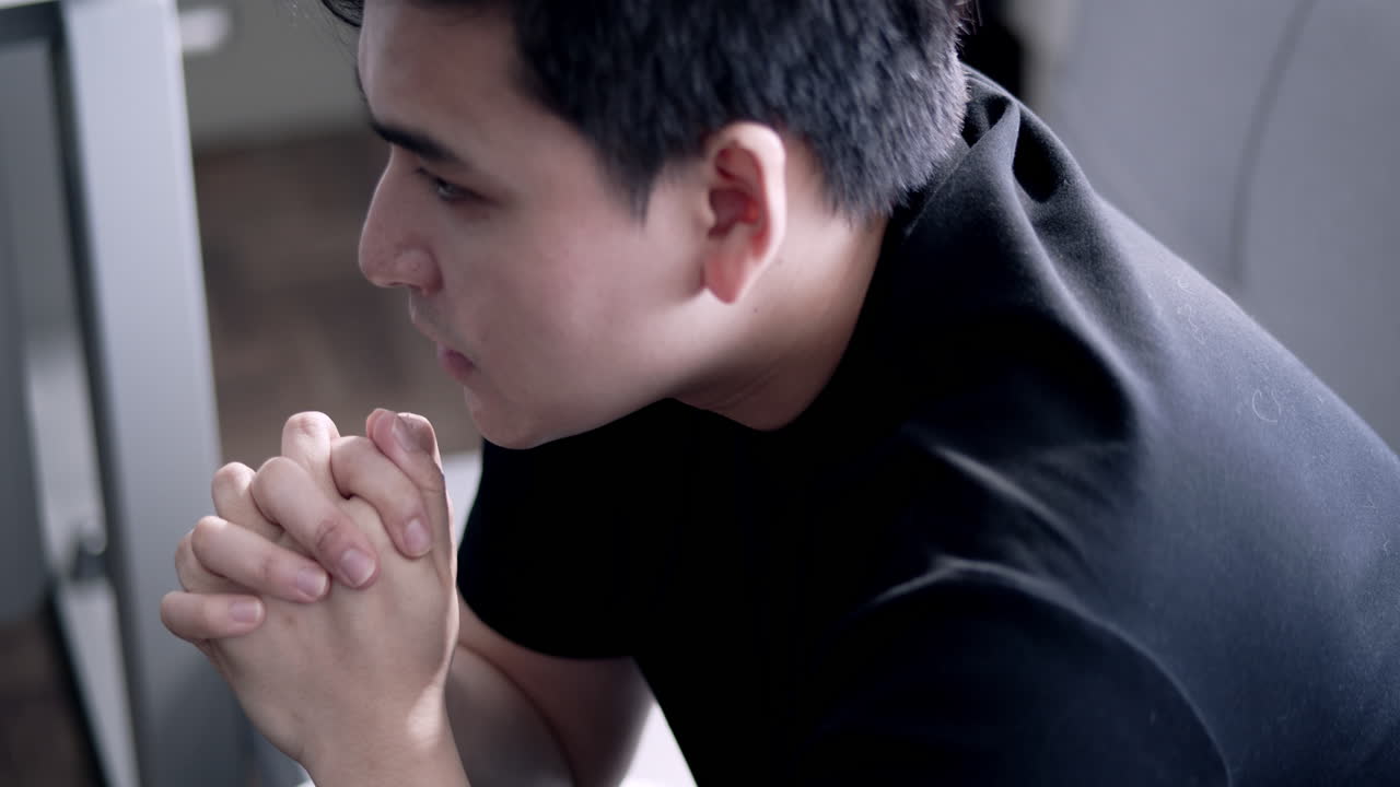 A young man deep in thought reflecting his life choices in a calm indoor environment.