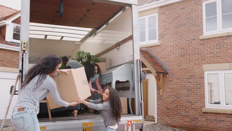 Familia-Descargando-Muebles-Del-Camión-De-Mudanzas-A-Una-Nueva-Casa.