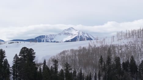 Erstaunliche-Luftaufnahme-Eines-Hohen-Berggipfels,-Eines-Schneebedeckten-Winterlandes