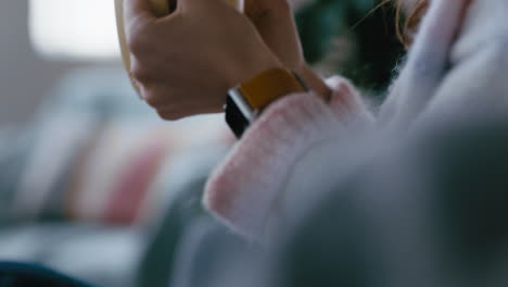 close-up-hands-woman-drinking-coffee-at-home-relaxing-on-couch-sipping-hot-beverage