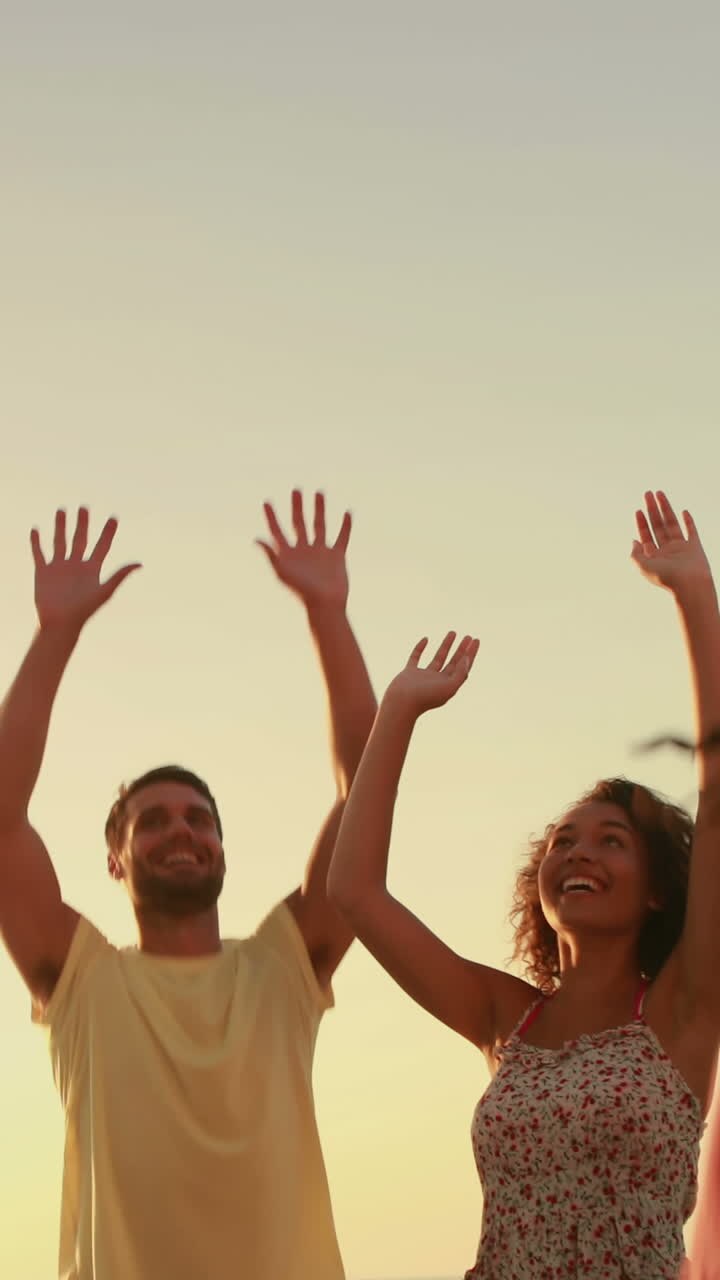 Amici che giocano con una palla in spiaggia