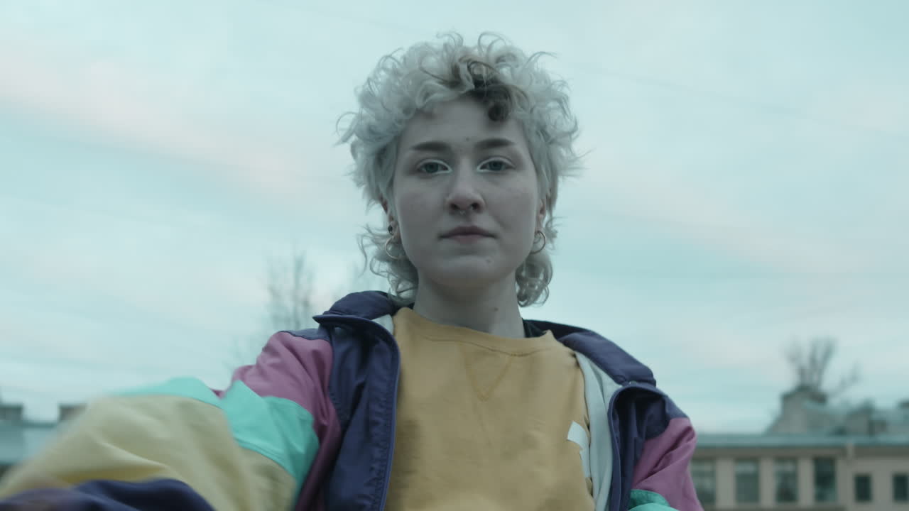 chica en chaqueta vintage bailando vogue a la cámara al aire libre