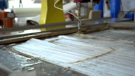 Taking-the-finished-product-made-from-a-glass-panel-with-a-CNC-water-jet-cutter-of-the-machine