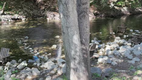 Chairs-in-the-river-stream,-relaxing-spot-in-forest