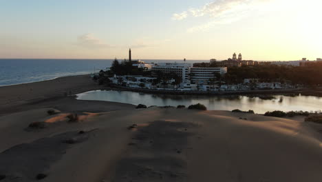 Increíble-Vista-De-Drones-A-Baja-Altitud-De-Una-Ciudad-Junto-Al-Mar-Cerca-De-La-Isla-De-Gran-Canaria-Maspalomas-En-España