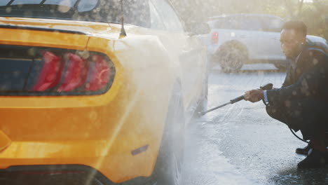 hombre lavando un coche descapotable amarillo