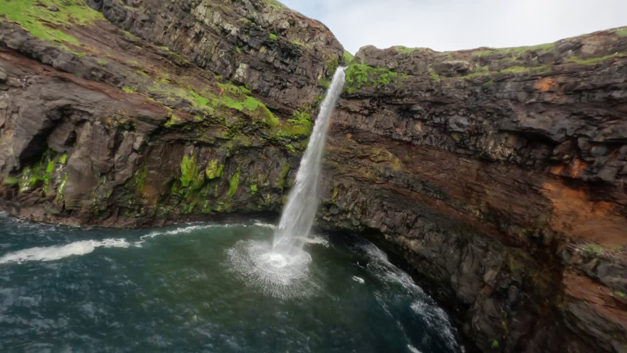 una impresionante vista aérea de la cascada de gásadalur, islas feroe, con un vuelo rápido en fpv