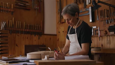 Gitarrenbauerin-Bei-Der-Arbeit-In-Ihrer-Werkstatt