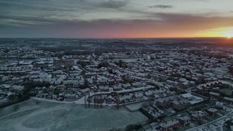 cinematic yorkshire winters morning dawn aerial scene showing rural housing and frost covered rooftops with morning sun breaking through the clouds