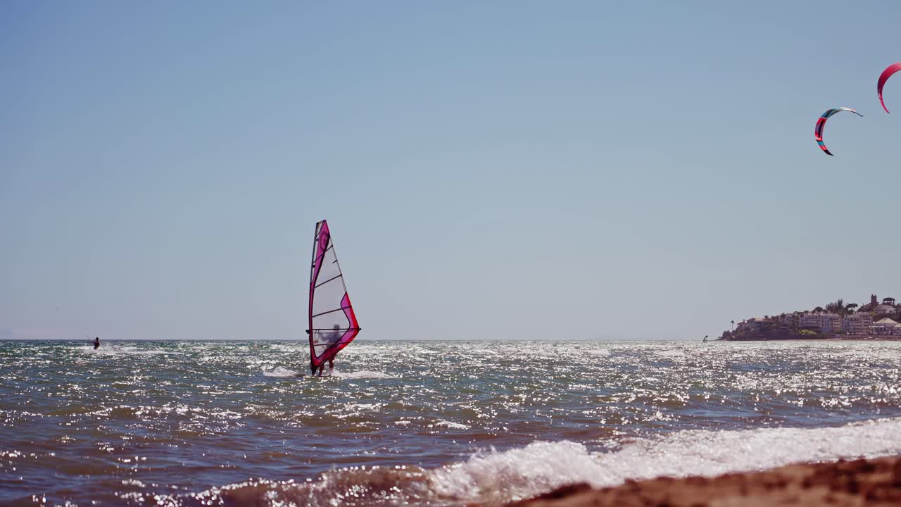 windsurfista en cámara lenta visto desde la playa