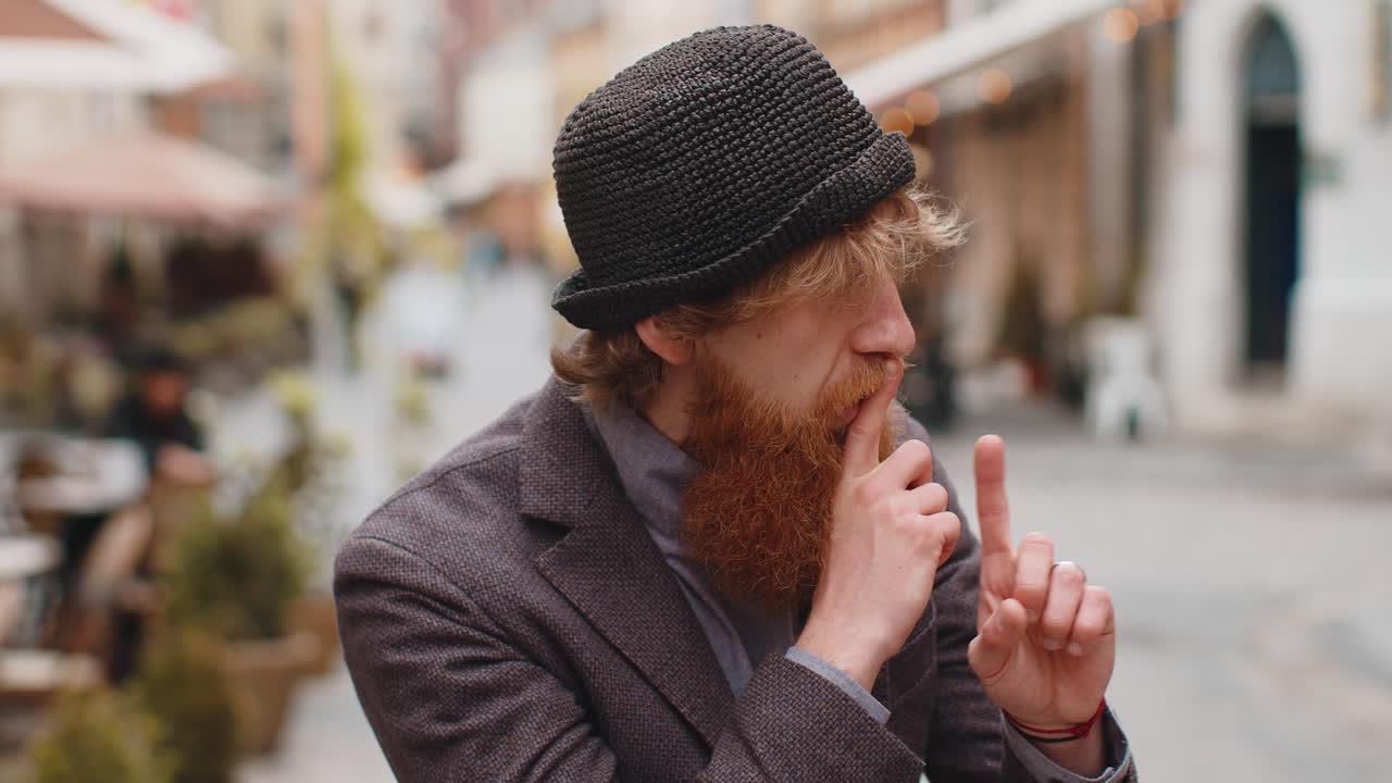 젊은이가 손가락을 입술에 고 침을 지키며, 침의 표지판, 소문, 비밀을 말하지 말라.