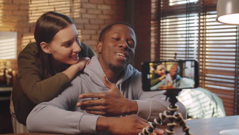 happy multiethnic couple recording vlog with smartphone