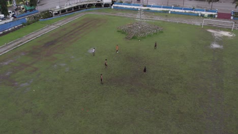 local kids playing football at soccer field at sumba indonesia, aerial
