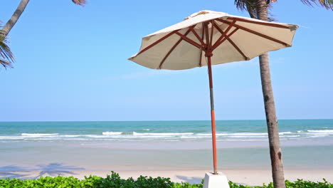 una sola sombrilla en la playa susurra con la brisa tropical