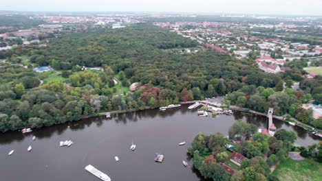 Recorriendo-Una-Isla-Rodeada-De-Una-Zona-Boscosa-En-Un-Río-Con-Barcos