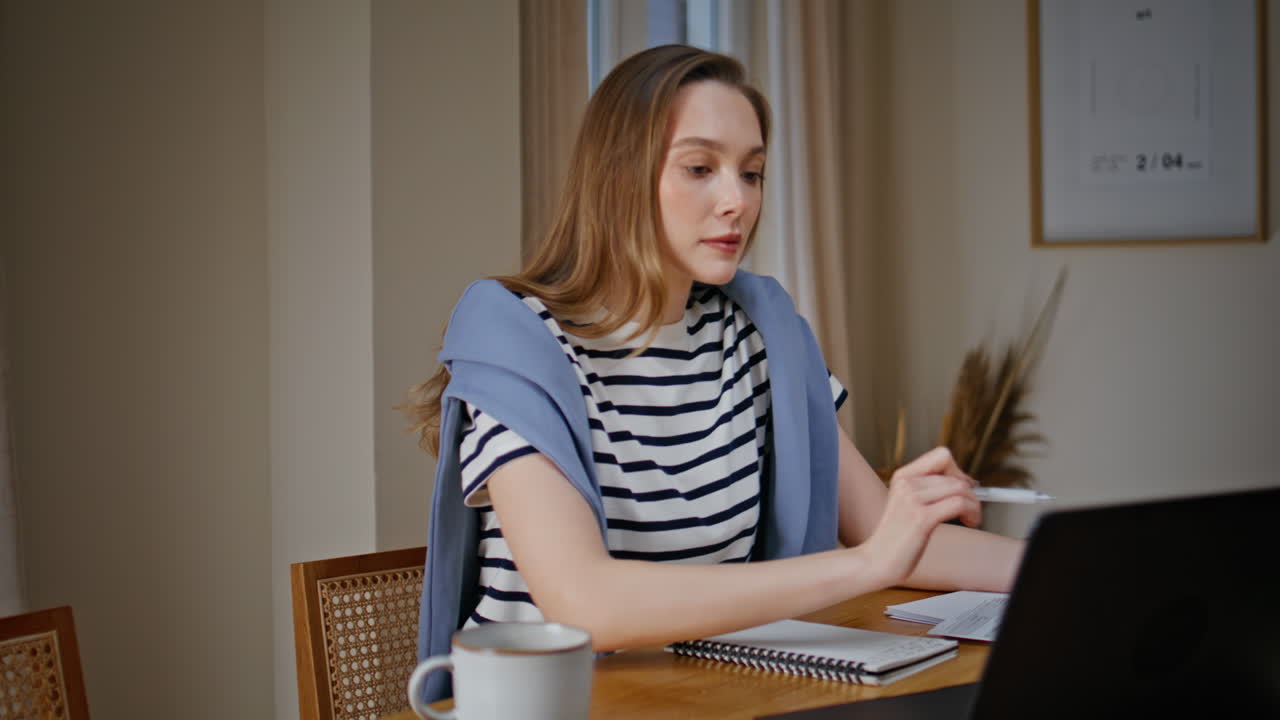 Focused woman watching educational seminar at laptop sitting apartment closeup
