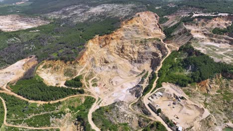 aerial shot of large stone quarry dug on the face of the mountain causing deforestation