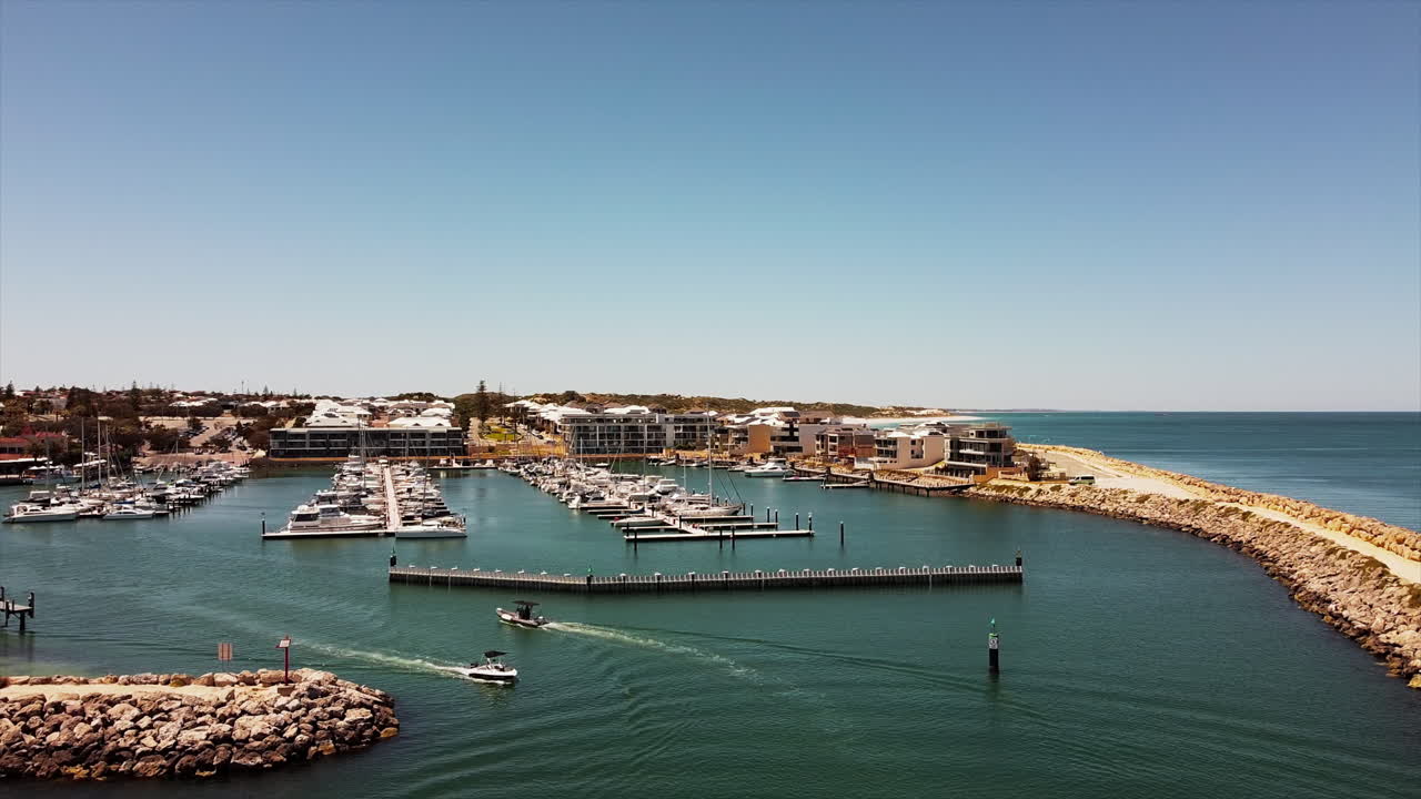 항구에 정박된 요트와 범선이 있는 해안선 마리나 베이 레지던스의 고급스러운 생활