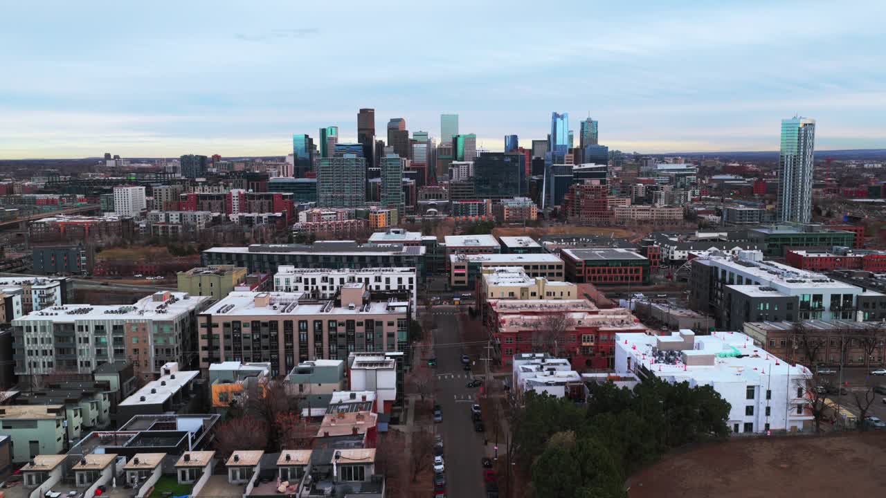 khu trung tâm thành phố Denver Lodo đường chân trời cảnh quan thành phố nhà chọc trời các tòa nhà mùa đông Colorado trên không flycam Công viên Highlands bầu trời xám xịt hoàng hôn buổi chiều đường cao tốc liên tiểu bang i25 xe cộ đường lộ dãy núi phía trước chuyển động lên trên