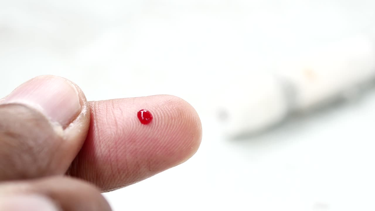 La mano del joven mide el nivel de glucosa en casa