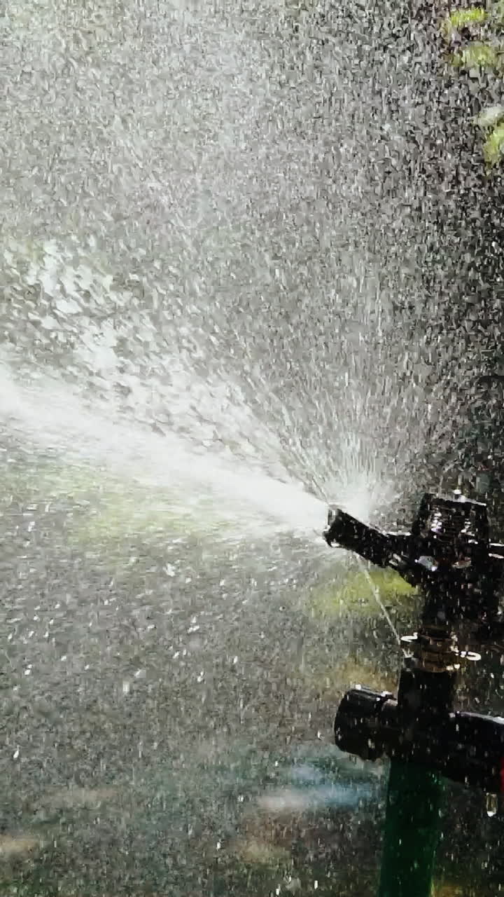 Device of irrigation garden. Irrigation of the green grass with sprinkler system. Vertical video