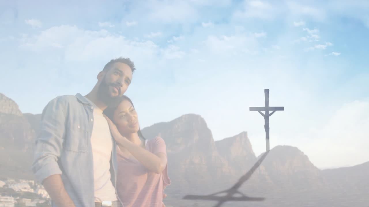 Embracing couple with mountain backdrop, cross shadow creating dramatic animation