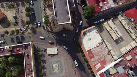 overhead shot of a vehicular intersection with moving cars, zooming in with the drone