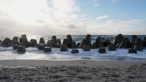 slow motion panning shot of the tetrapods protecting the shore from the waves at the beach of hörnum located at the island of sylt