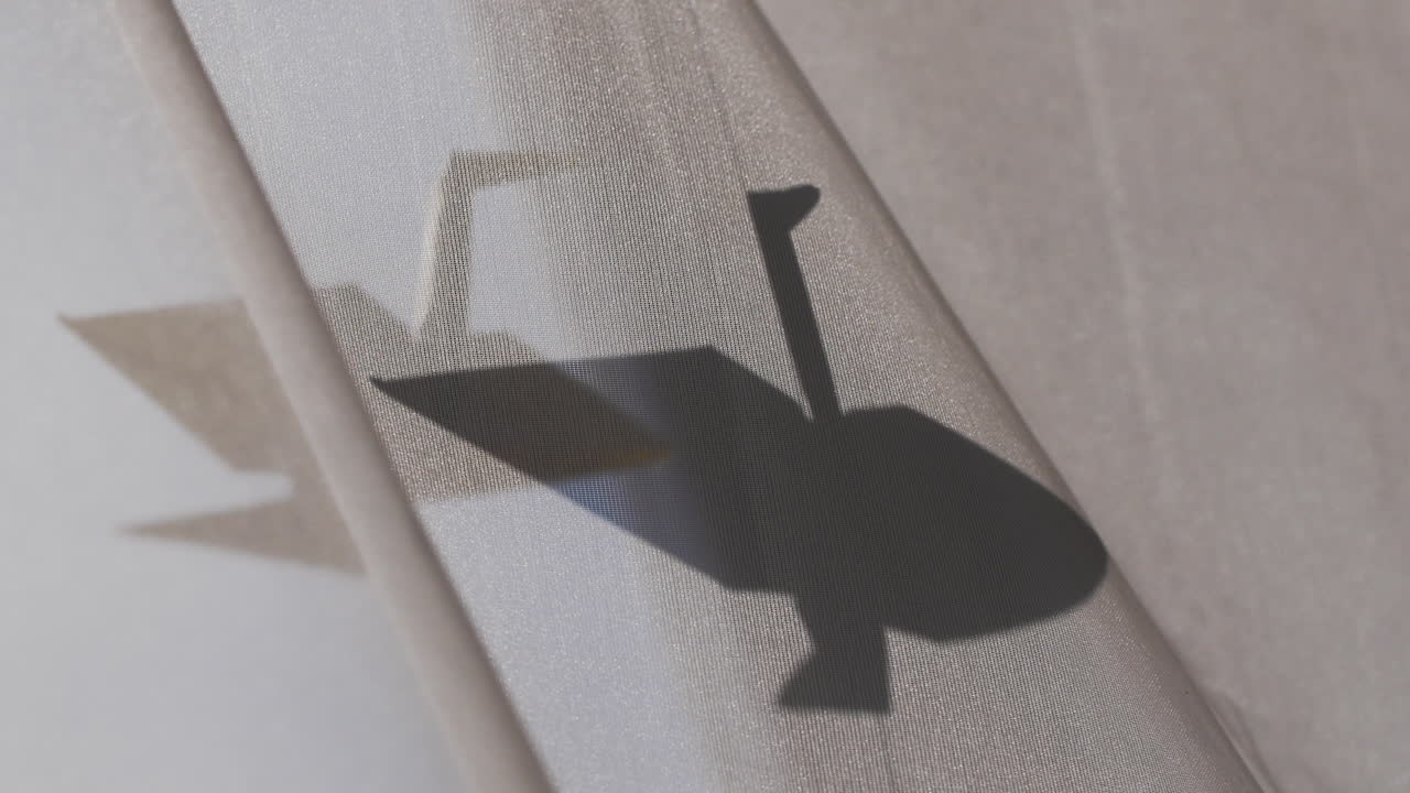 종이접기 크레인이 햇빛에 매달려 있다